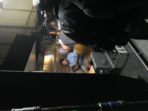 Crew reviewing a shot on a tablet between takes on a soundstage set.